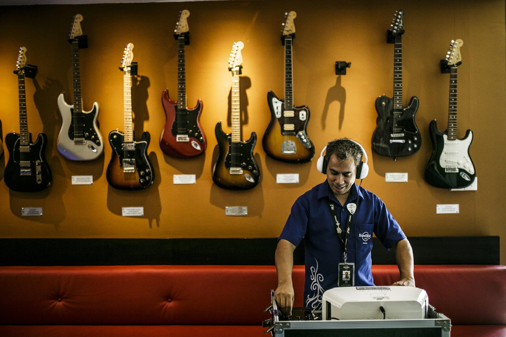 Hard Rock Hotel Penang Batu Ferringhi Zewnętrze zdjęcie A guitar store employee listens to a customer's selection